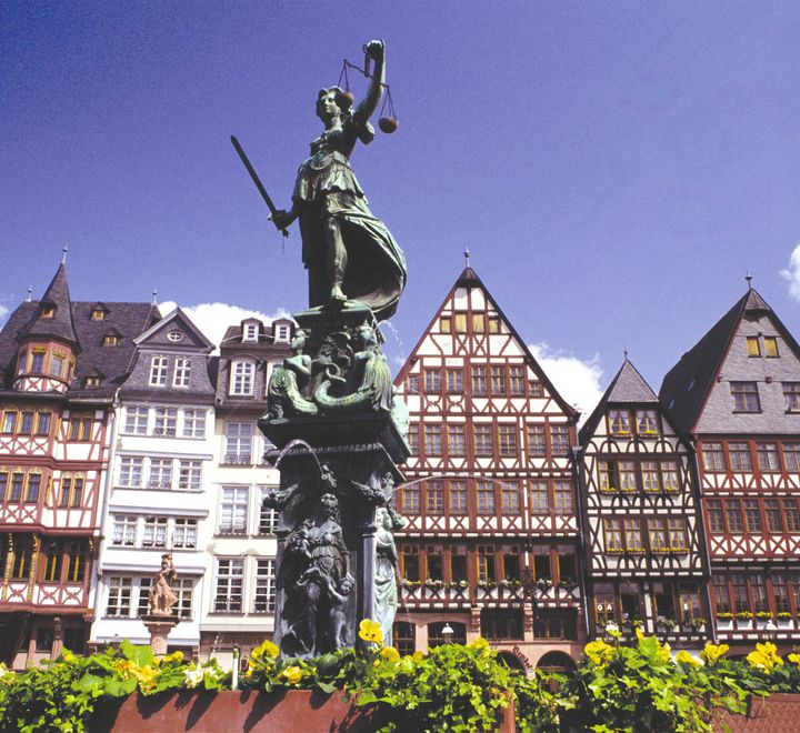 En statue med tyrolerhus i bakgrunnen